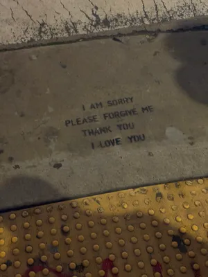 Hoʻoponopono forgiveness phrases stenciled on a city sidewalk