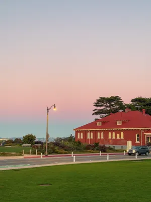 Red brick barracks in the Presidio at dusk under a pink and blue twilight sky